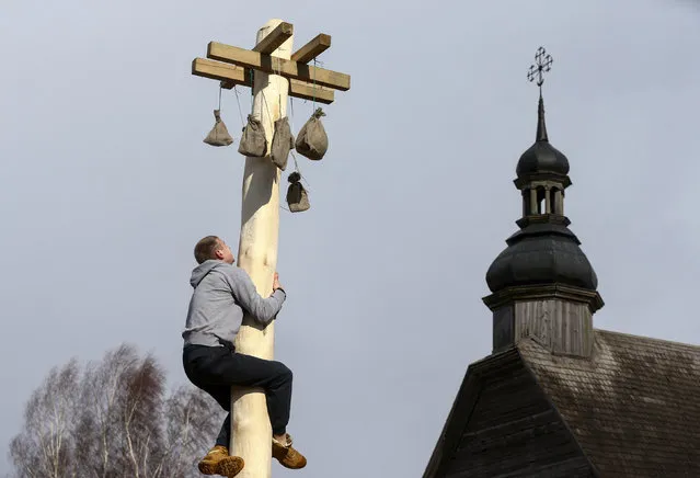 A man climbs up a wooden pole to get a prize during celebration of Maslenitsa, or Pancake Week, in the Aziarco village, Belarus, February 25, 2017. (Photo by Vasily Fedosenko/Reuters)