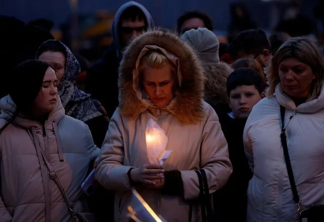 A woman holds a candle at a memorial to the victims of the shooting attack near Moscow, Russia, on March 23, 2024. (Photo by Maxim Shemetov/Reuters)