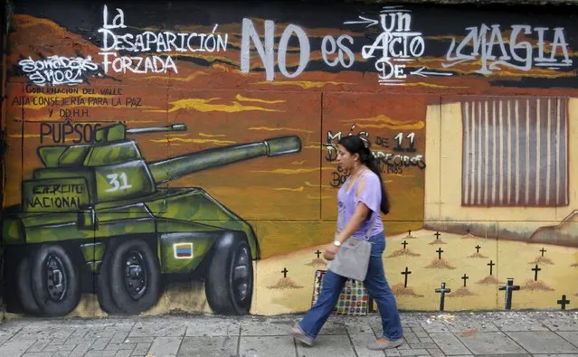 A woman walks in front of a mural during a commemoration day to show solidarity with the victims of armed conflict, in Cali, Colombia April 9, 2016. The mural reads: “Forced disappearance is not by magic”. (Photo by Jaime Saldarriaga/Reuters)