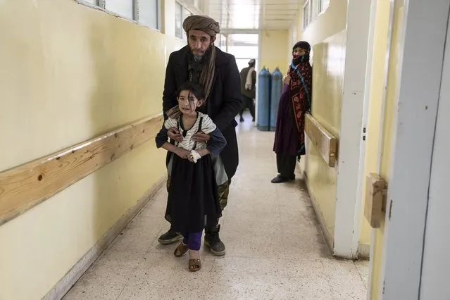 A girl walks with the help of her father in Indira Gandhi Children's Hospital in Kabul, Afghanistan, on Wednesday, December 8, 2021. (Photo by Petros Giannakouris/AP Photo)