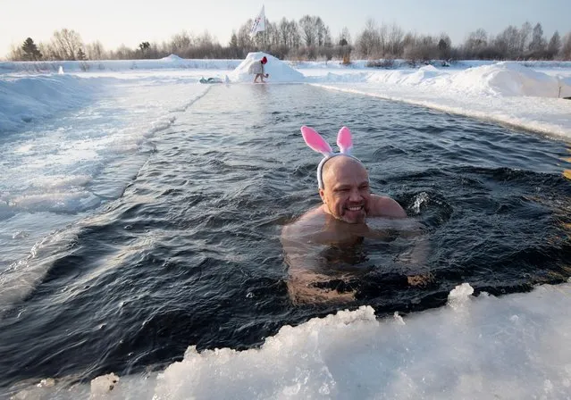Members of a local winter swimming club take part in festive bathing in the icy waters of Boyarskoye lake outside Tomsk, Russia, December 26, 2021. (Photo by Taisiya Vorontsova/Reuters)
