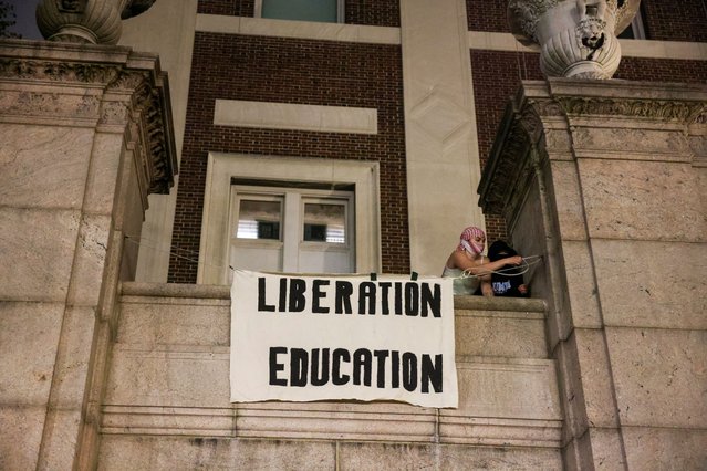 Protesters hang banners on the exterior of Hamilton Hall building after barricading themselves inside the building at Columbia University, after an earlier order from university officials to disband the protest encampment supporting Palestinians, or face suspension, during the ongoing conflict between Israel and the Palestinian Islamist group Hamas, in New York City, U.S., April 30, 2024. (Photo by Caitlin Ochs/Reuters)