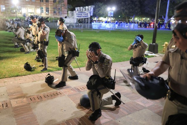 CHP officers put on their gear amid clashes near an encampment (not pictured) by supporters of Palestinians in Gaza, on the University of California, Los Angeles (UCLA) campus, amid the ongoing conflict between Israel and the Palestinian Islamist group Hamas, in Los Angeles, California, U.S., May 1, 2024. (Photo by David Swanson/Reuters)