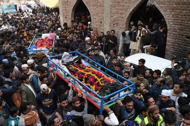 Mourners carry the coffins of victims, who died trapped in a traffic jam when a blizzard from January 7 onwards felled trees and blocked narrow roads leading in and out of the resort hill town of Murree, during the funeral in Lahore on January 9, 2022. Army rescuers on January 9 cleared routes around a Pakistan hill town sheltering thousands of tourists after 22 people died in vehicles trapped by heavy snow. (Photo by Arif Ali/AFP Photo)