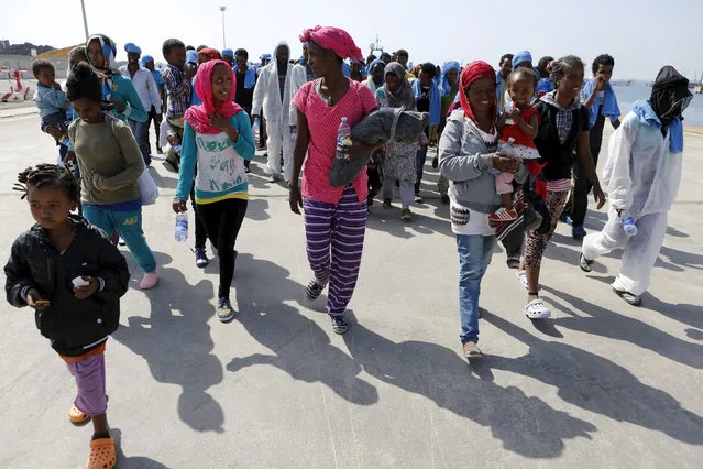 Migrants walk after disembarking from the expedition vessel Phoenix in the Sicilian harbour of Augusta, Italy June 17, 2015. REUTERS/Antonio Parrinello