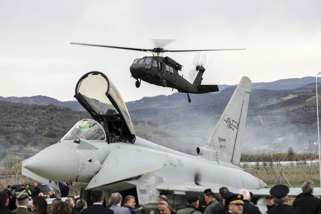 A military helicopter lands near an Italian Eurofighter at an airbase during a ceremony, in Kocuve, about 85 kilometers (52 miles) south of Tirana, Albania, Monday, March 4, 2024. NATO member Albania inaugurated an international tactic air base on Monday, the Alliance's first one in the Western Balkan region. (Photo by Armando Babani/AP Photo)
