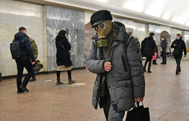 A man in a gas mask walks through an underpass at a subway station as protection against coronavirus in Moscow, Russia on January 27, 2022. (Photo by Kommersant Photo Agency/Rex Features/Shutterstock)