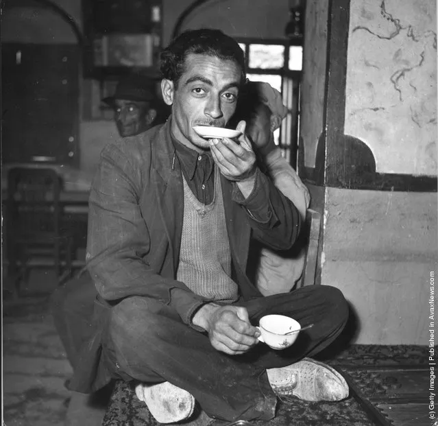 1955:  An Iranian man finishing his cup of tea from the saucer
