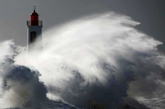 Waves crash against a lighthouse during Storm Nelson in Les Sables d'Olonne, France, on March 28, 2024. (Photo by Stephane Mahe/Reuters)
