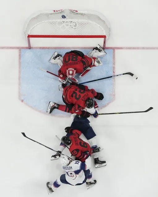 Canada goalkeeper Eddie Pasquale (80), Canada's Owen Power (22), United States' Nathan Smith, center, Canada's Jason Demers (60) and United States' Brendan Brisson (19) scramble for the puck during a preliminary round men's hockey game at the 2022 Winter Olympics, Saturday, February 12, 2022, in Beijing. (Photo by Matt Slocum/AP Photo)