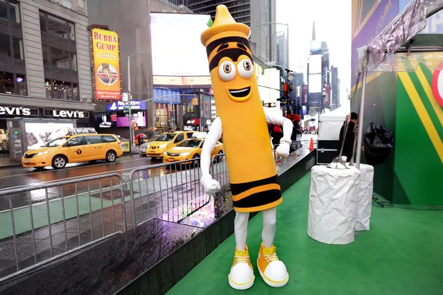 A dandelion crayon character poses for photos during a Crayola event in New York's Times Square, Friday, March 31, 2017. Crayola announced Friday, National Crayon Day, that it's replacing the color dandelion in its 24-pack with a crayon in “the blue family”. (Photo by Richard Drew/AP Photo)