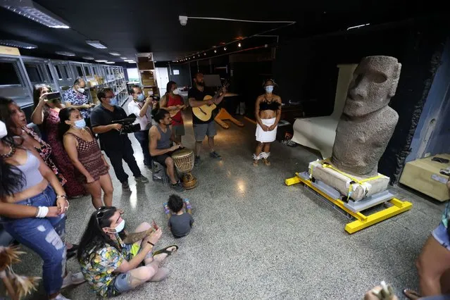 Rapa Nui natives play music to a Moai statue from Easter Island while it is displayed at the Natural History Museum before returning to the island, in Santiago, Chile, February 21, 2022. (Photo by Ivan Alvarado/Reuters)