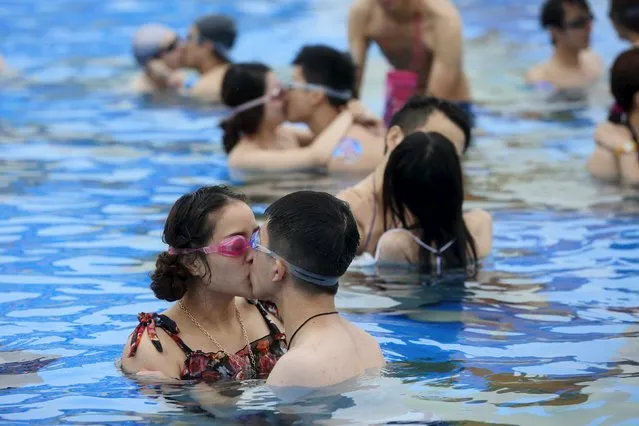 Couples kiss at a swimming pool during a kissing contest in Shanghai July 5, 2015. About 20 couples took part in the game and the winning couple who held their kiss for the longest time won a diamond ring, according to local media. (Photo by Reuters/China Daily)