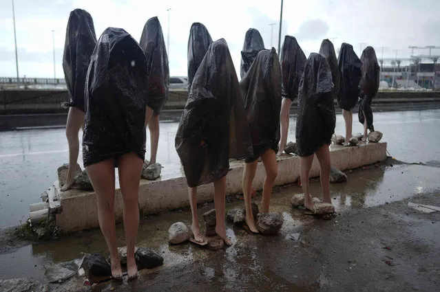 Mannequins are covered with a plastic bag to protect them from the rain during carnival celebration in La Guaira, Venezuela, Monday, February 28, 2022. (Photo by Ariana Cubillos/AP Photo)