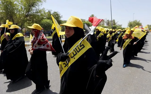 Iraqi Shiite Muslim women wave Iraqi Hezbollah flags during a parade marking the annual al-Quds Day, or Jerusalem Day, on the last Friday of the Muslim holy month of Ramadan in Baghdad, July 10, 2015. (Photo by Thaier al-Sudani/Reuters)