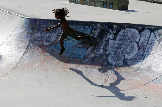 In this July 9, 2015 photo, a young skater falls as he plays in a skate park in Milan, Italy. (Photo by Antonio Calanni/AP Photo)