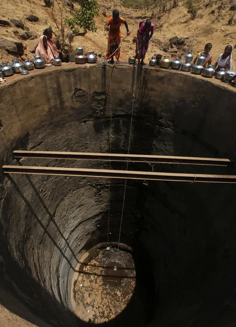 Women pulling a rope attached to a bucket as they draw drinking water from a dried up well at Bhakrecha Pada in Thane district in Maharashtra state, India, Wednesday, May 4, 2016. Much of India is reeling under a weekslong heat wave and severe drought conditions that have decimated crops, killed livestock and left at least 330 million Indians without enough water for their daily needs. (Photo by Rajanish Kakade/AP Photo)