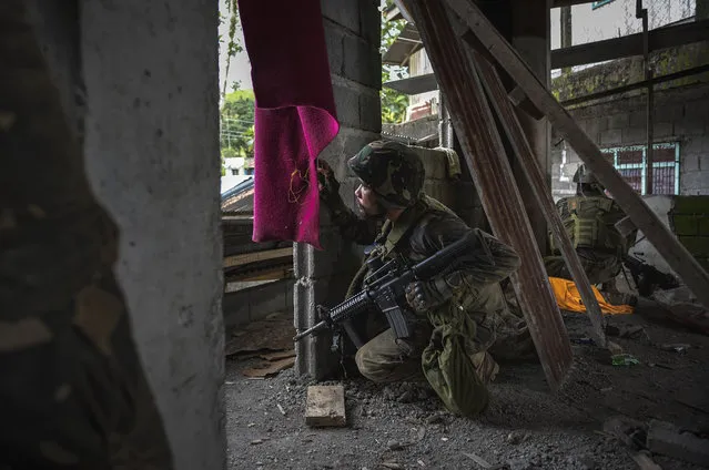 A soldier taking a look at enemy positions, while they try to clear the city of armed militants, one street at a time on May 25, 2017 in Marawi city, southern Philippines. Gun battles between ISIS-linked militants and Filipino troops erupted in Marawi city on Tuesday when gunmen from the local terrorist organizations Maute Group and Abu Sayyaf rampaged through the southern city setting buildings on fire. President Rodrigo Duterte has declared 60 days of martial law in Mindanao as thousands of residents were reported to have fled from Malawi city while at least 21 people were killed, including a police chief who had been beheaded. President Duterte said the influence of Islamic State is one of the nation's top security concerns, and martial law on Mindanao island could be extended across the Philippines to enforce order, allowing the detention of people without charges. (Photo by Jes Aznar/Getty Images)