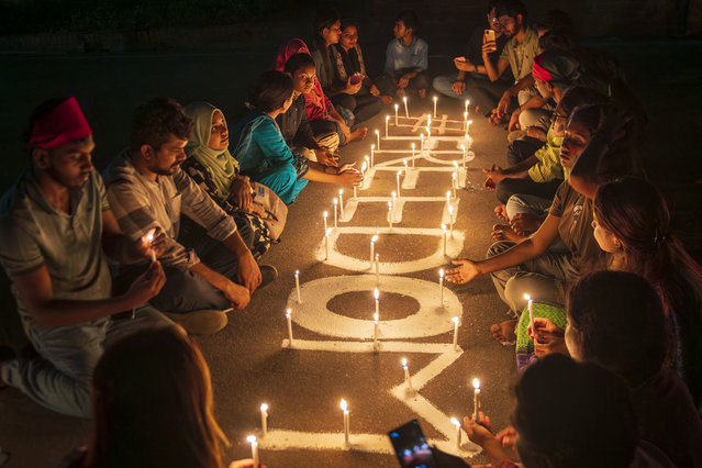 Students light candles to pay tribute to the students, who have died during the quota movement protests in front of the national parliament on August 8, 2024 in Dhaka, Bangladesh. (Photo by Istiak Karim/Drik/Getty Images)