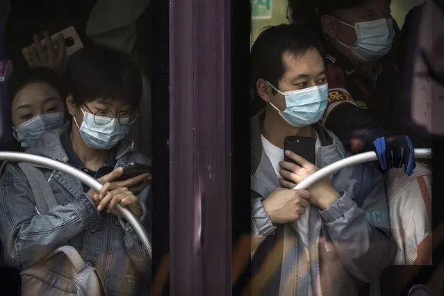 Commuters wearing face masks to help protect from the coronavirus ride on a crowded bus traveling from the outskirts of the capital city clogged in heavy traffic on a road during the morning rush hour, Monday, April 18, 2022, in Beijing. China’s economic growth edged up to a still-weak 4.8% over a year earlier in the first three months of 2022 as spreading coronavirus outbreaks prompted shutdowns of major industrial cities. (Photo by Andy Wong/AP Photo)
