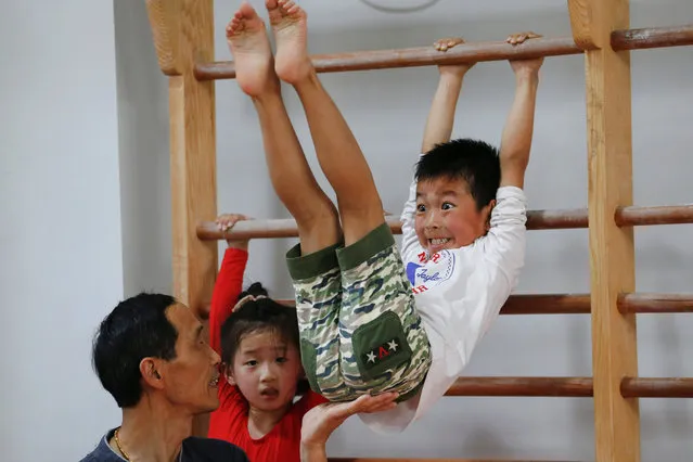A boy practices as his coach assists during gymnastics lessons at the Shanghai Yangpu Youth Amateur Athletic School in Shanghai, China, May 4, 2016. China's sports system has been enormously successful since the country returned to the Olympic fold in 1980, culminating with the host nation topping the medals' table at the 2008 Beijing Olympics. And yet, with the Rio de Janeiro Games less than three months away, the system is beginning to break down due to the shifting demographics of a more prosperous nation. Some schools have closed and others are adjusting the way they work. (Photo by Aly Song/Reuters)