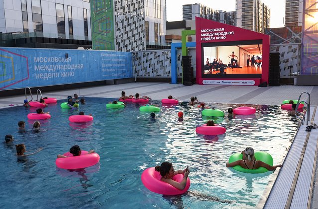 People on inflatable floats watch a movie on a screen in the Akvatoria ZIL swimming pool during the Moscow International Film Week, in Moscow, Russia on August 28, 2024. (Photo by Evgenia Novozhenina/Reuters)