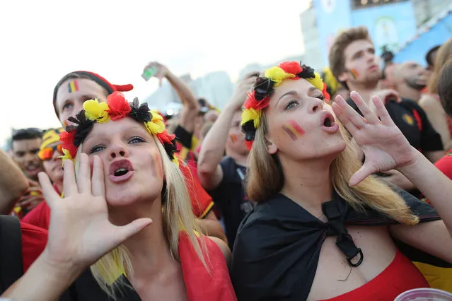Belgium soccer fans cheer as they wait for the live telecast of the World Cup round of 16 match against the United States, inside the FIFA Fan Fest area on Copacabana beach in Rio de Janeiro, Brazil, Tuesday, July 1, 2014. (Photo by Leo Correa/AP Photo)