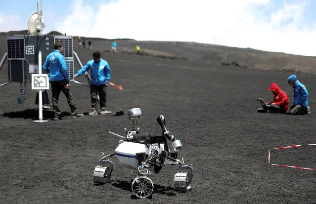 Scientists from German Aerospace Center are seen working as they test some robots on the Mount Etna, Italy on July 4, 2017. (Photo by Antonio Parrinello/Reuters)