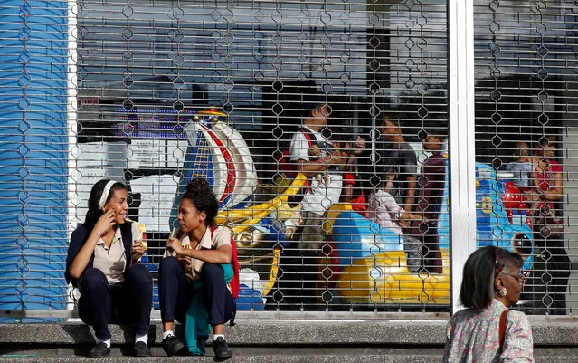 People sit outside a shopping mall in Caracas, Venezuela, June 23, 2016. (Photo by Mariana Bazo/Reuters)
