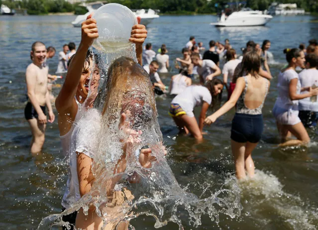 Youngsters play with water during a flash mob called “Water battle” on a hot summer day on the bank of the Dnipro river in Kiev, Ukraine, July 2, 2016. (Photo by Valentyn Ogirenko/Reuters)