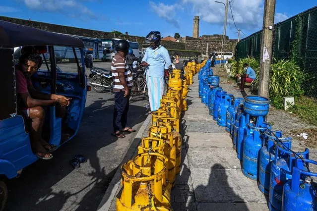 People to buy Liquefied Petroleum Gas (LPG) cylinders near the Galle International Cricket Stadium in Galle on June 28, 2022. (Photo by Ishara S. Kodikara/AFP Photo)