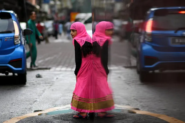 A Muslim girl leaves after Eid al-Fitr prayers at Masjid India in Kuala Lumpur on June 25, 2017. Eid al-Fitr festival marks the end of the holy Muslim fasting month of Ramadan. (Photo by Manan Vatsyayana/AFP Photo)