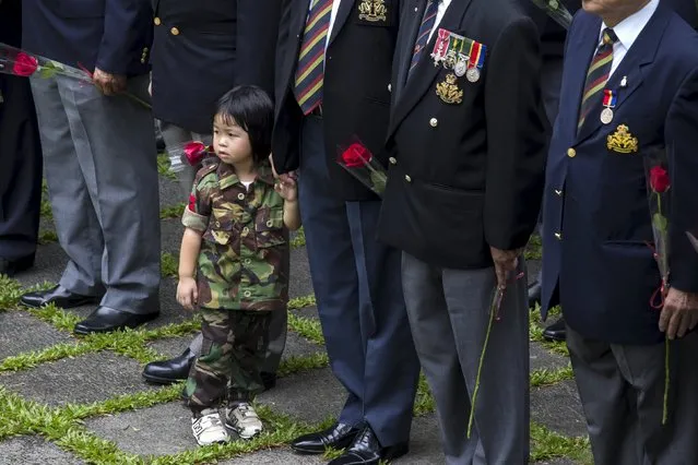 A girl from Hong Kong Adventure Corps attends a ceremony to commemorate the 70th anniversary of Victory over Japan (VJ) Day in Hong Kong, China August 16, 2015. (Photo by Tyrone Siu/Reuters)