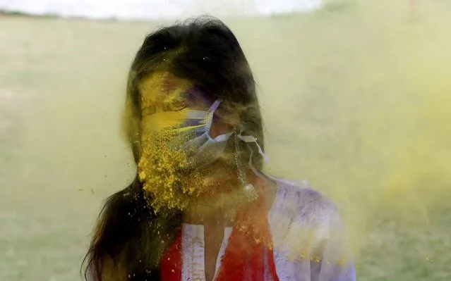 An Indian college student wearing a face mask as precautionary measure against the COVID-19 coronavirus attends Holi festival celebrations in Bhopal, India, 09 March 2020. The Holi festival is celebrated on the full moon day and heralds the onset of spring season. (Photo by Sanjeev Gupta/EPA/EFE)