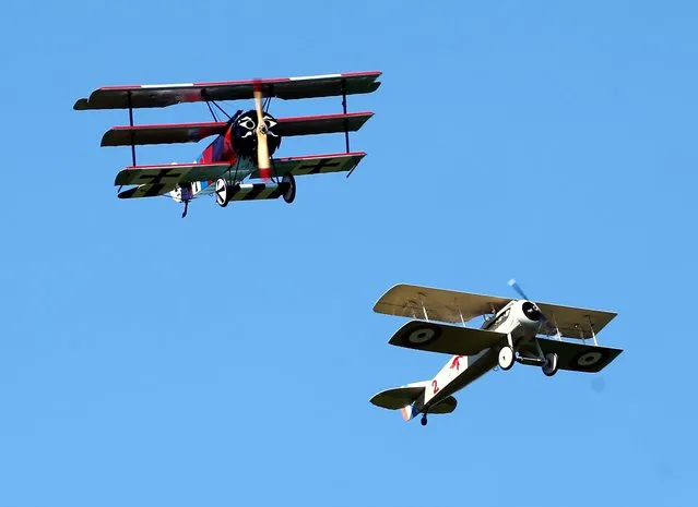 A World War 1-era Fokker DR-1 tri-plane and Spad VII bi-plane, both reproductions, perform a dog fight during an air show at the Old Rhinebeck Aerodrome on Sunday, July 6, 2014, in Rhinebeck, N.Y. (Photo by Mike Groll/AP Photo)