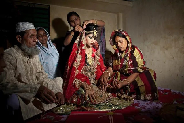 Nasoin Akhter, 15, sits with relatives while posing for photos on the day of her wedding to a 32-year-old man on August 20, 2015, in Manikganj, Bangladesh. (Photo by Allison Joyce/Getty Images)