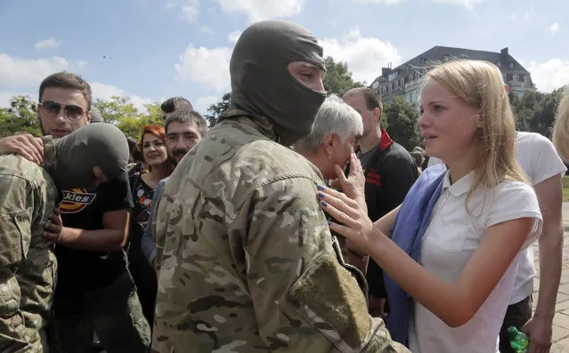 Friends and relatives say goodbye to volunteers before they were sent to the eastern part of Ukraine to join the ranks of special battalion “Azov” fighting against pro-Russian separatists, in Kiev, Ukraine, Sunday, August 17, 2014. (Photo by Efrem Lukatsky/AP Photo)