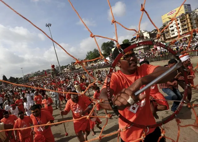 Devotees run to take a dip in the Godavari river during the first Shahi Snan (grand bath) at Kumbh Mela, or Pitcher Festival in Nashik, India, August 29, 2015. (Photo by Danish Siddiqui/Reuters)