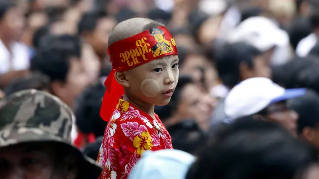 A child wears the headband with a picture of the late General Aung San, waits outside the Martyrs' Mausoleum, during a ceremony marking the 69th Martyrs' Day at the Martyrs' Mausoleum in Yangon, Myanmar, 19 July 2016. Myanmar's Martyr's Day is observed on 19 July to commemorate country's nine independence heroes including General Aung San, the father of Myanmar State counsellor Aung San Suu Kyi, who were assassinated on 19 July in 1947. (Photo by Nyein Chan Naing/EPA)