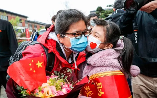 This photo taken on March 31, 2020 shows a member (L) of a medical assistance team from Huaian being welcomed by her daughter after returning home from Wuhan to help with the COVID-19 coronavirus recovery effort in Huaian in China's eastern Jiangsu province. (Photo by AFP Photo/China Stringer Network)