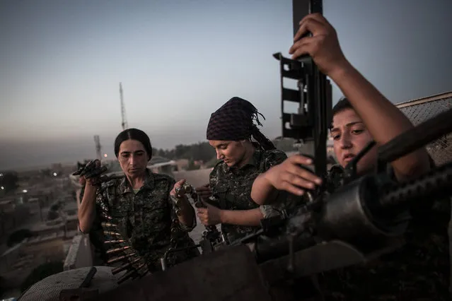 Captain Ronahi Anduk, 34, left, Gian Dirik, center, and Dirsim Judi, 18, right, work on the Dushka weapon at the YPJ center in the town of Til Colture, on the border of Syria and Kurdistan on Aug. 9, 2014. (Photo by Erin Trieb/NBC News)