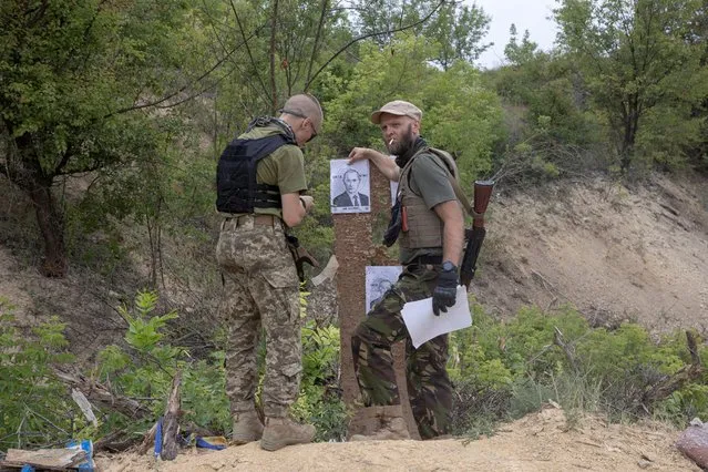 Members of the Carpathian Sich battalion prepare targets depicting Russian President Vladimir Putin during an exercise for new recruits at a shooting range in Kharkiv region, Ukraine, June 30, 2022. The Carpathian Sich is one of several paramilitary nationalist groups that began as volunteers in 2014, when Russia annexed the Black Sea peninsula of Crimea and backed pro-Russian armed separatists in Ukraine's eastern Donbas region. (Photo by Marko Djurica/Reuters)
