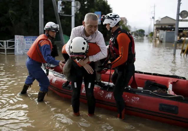 An elderly man is rescued by firefighters at a residential area flooded by the Kinugawa river, caused by typhoon Etau in Joso, Ibaraki prefecture, Japan, September 11, 2015. (Photo by Issei Kato/Reuters)
