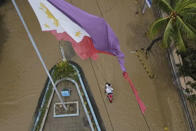 A tattered Philippine flag is seen over a flooded road due to Typhoon Noru in San Miguel town, Bulacan province, Philippines, Monday, September 26, 2022. (Photo by Aaron Favila/AP Photo)