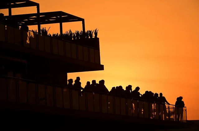 A silhouette of fans watching play from Club 54 on the 18th green is seen as the sun sets during day three of the LIV Golf Invitational – Jeddah at Royal Greens Golf & Country Club on October 16, 2022 in King Abdullah Economic City, Saudi Arabia. (Photo by Charles Laberge/LIV Golf via Getty Images)