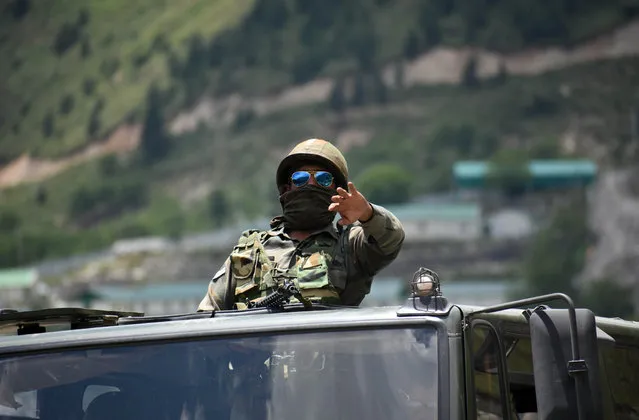 An Indian army soldier on top a military vehilce gestures along the Srinagar-Leh National highway on June 17, 2020.At least 20 Indian soldiers were killed in a violent clash with Chinese forces in a disputed border area. (Photo by Faisal Khan/Anadolu Agency via Getty Images)
