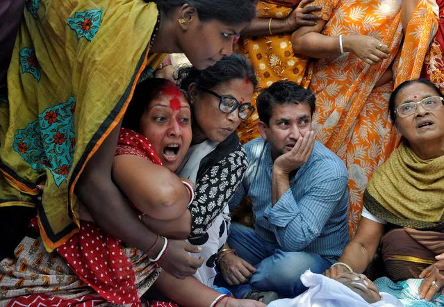 Shima (in red) mourns next to the body of her husband Sudip Datta Bhowmik, a local journalist, who according to local media was shot dead by a Tripura State Rifles trooper on Tuesday, in Agartala, India, November 22, 2017. (Photo by Jayanta Dey/Reuters)