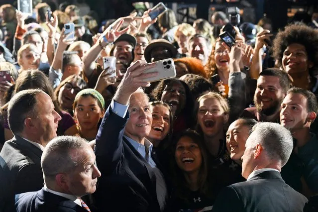 US President Joe Biden (C) poses for a selfie with supporters during a rally for Democratic candidates, including New York Governor Kathy Hochul, at Sarah Lawrence College in Bronxville, New York, on November 6, 2022. (Photo by Saul Loeb/AFP Photo)