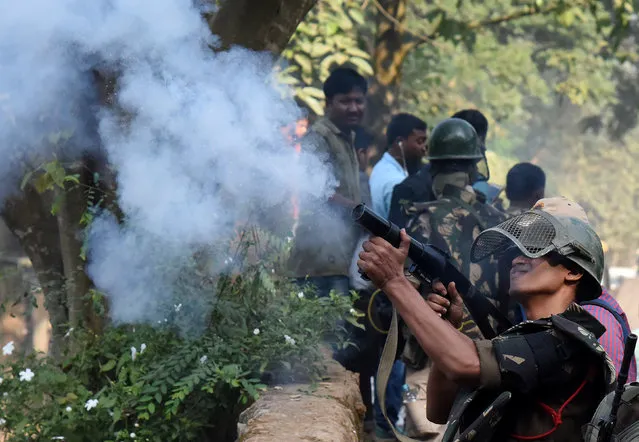 A policeman fires a teargas shell to disperse the residents, as police arrives to demolish huts which forest officials claimed were illegally built at the Amchang Wildlife Sanctuary, in Guwahati, November 27, 2017. (Photo by Anuwar Hazarika/Reuters)