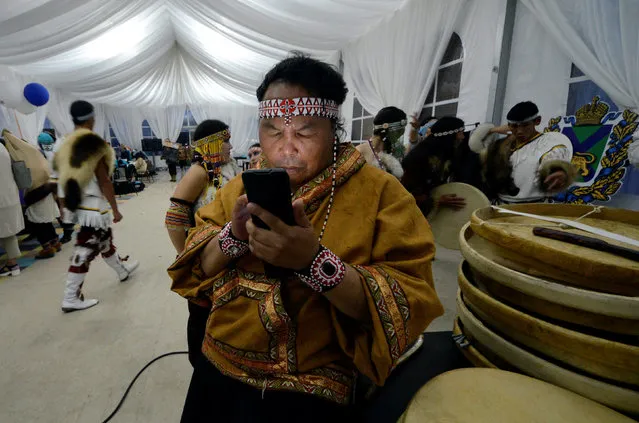 A member of an ensemble, specialising in the culture of Chukchi and Eskimo peoples, uses a smartphone backstage during a concert shortly before the closing of the Eastern Economic Forum in Vladivostok, Russia, September 3, 2016. (Photo by Yuri Maltsev/Reuters)